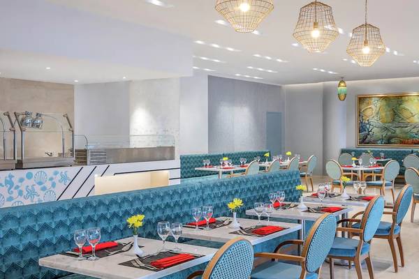 Innenansicht des Restaurants im Hilton Hurghada Plaza mit blauen Möbeln und Gemälden.