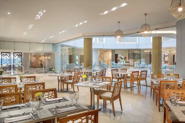 Innenansicht des Restaurants im Hilton Hurghada Plaza mit gedeckten Tischen und Stühlen.