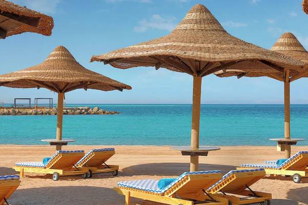 Strandszene mit Sonnenliegen und Palmenschirmen am Hilton Hurghada Plaza.