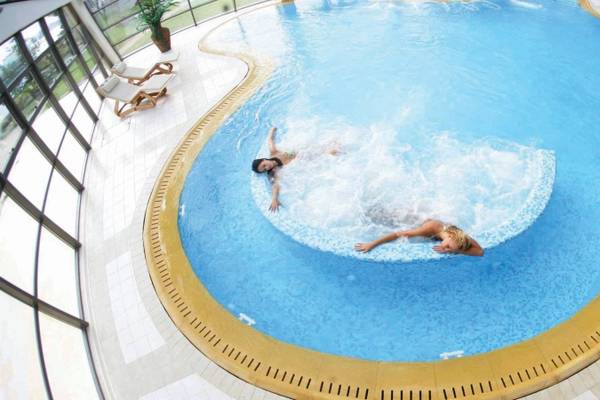 Zwei Frauen schwimmen im Porto Carras Meliton Schwimmbecken.
