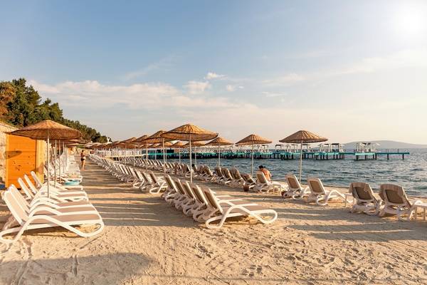 Strand mit vielen Liegen und Sonnenschirmen des Hotels Duja Bodrum am Meer