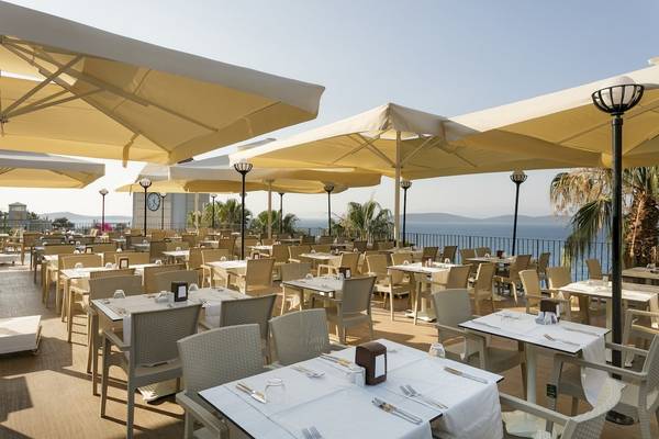 Terrasse des Duja Bodrum Hotels mit Blick auf das Meer und gesäumt von großen Sonnenschirmen.