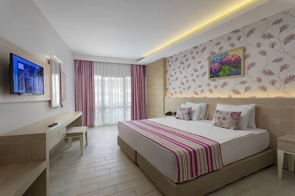 Hotelzimmer im Duja Bodrum mit Fernseher, Bett, Schreibtisch und Stuhl.