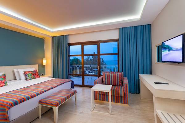 Hotelzimmer im Duja Bodrum mit Meerblick, Bett, Sessel und Fernseher.
