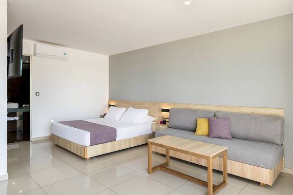CHC Galini Palace Hotel Zimmer mit Bett, Sofa und Tisch.
