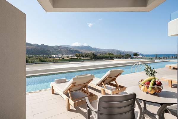 Außenterrasse des CHC Galini Palace Hotels mit Blick auf den Swimmingpool, Liegen und Obstkorb.