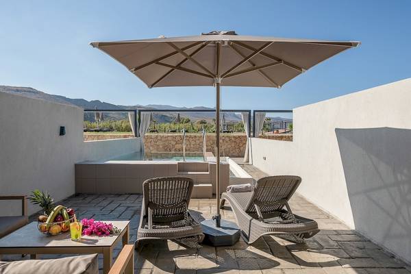 Terrasse mit Liegestühlen und Sonnenschirm im CHC Galini Palace