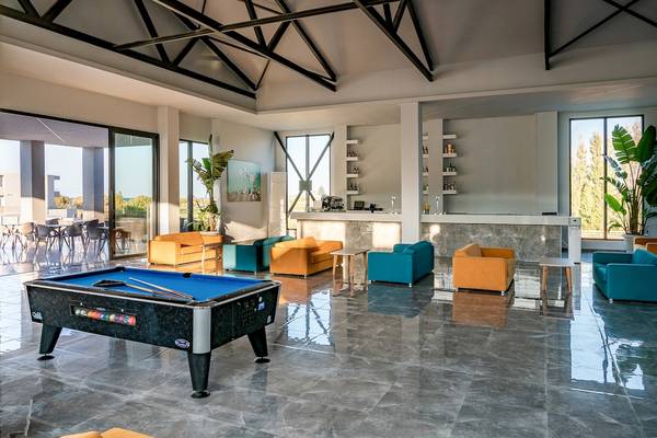 Poolhalle im CHC Galini Palace Hotel mit Billardtisch und Sofas.