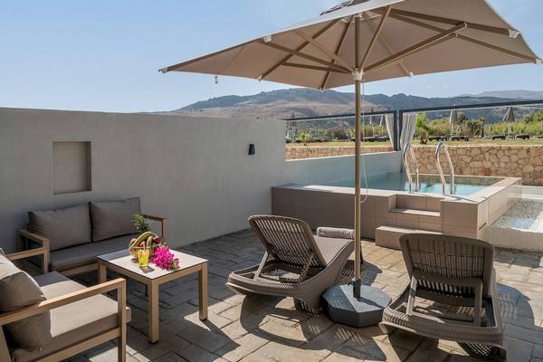 Terrasse des CHC Galini Palace mit Sonnenliegen und einem Tisch, an dem eine bunte Obstschale steht