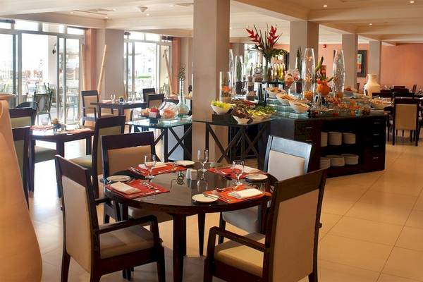 Innenansicht des Restaurants im Crowne Plaza Muscat mit gedeckten Tischen und Buffet.