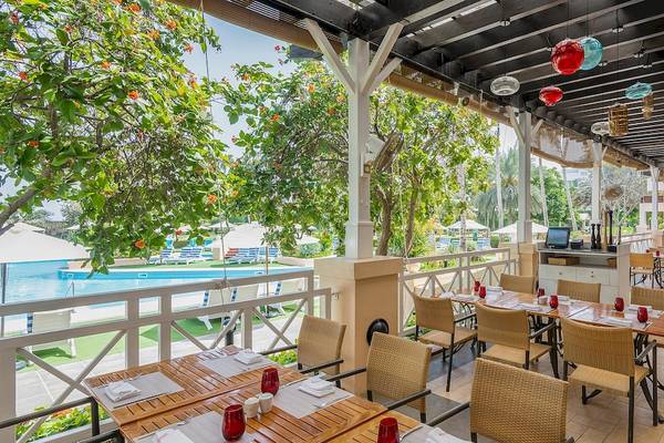 Restaurantterrasse des InterContinental Muscat mit Blick auf den Pool und Garten.