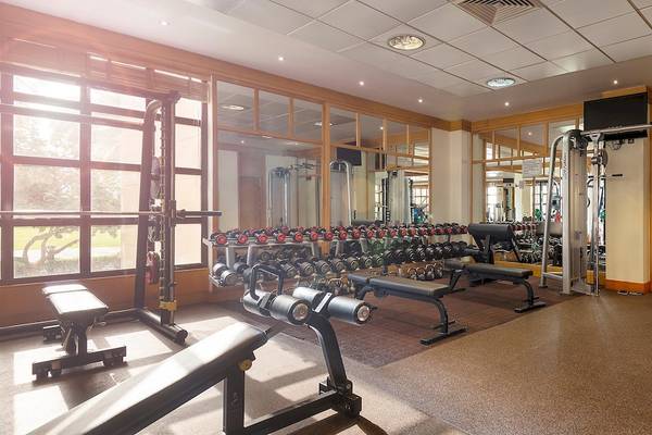Fitnessstudio im InterContinental Muscat mit vielen Geräten und großen Fenstern.