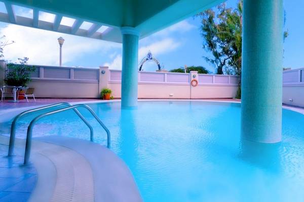 Außenpool des Mediterranean Hotel auf Rhodos mit blauem Wasser und hellblauen Säulen.