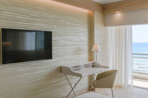 Zimmer im Mediterranean Hotel auf Rhodos mit Fernseher und Schreibtisch.