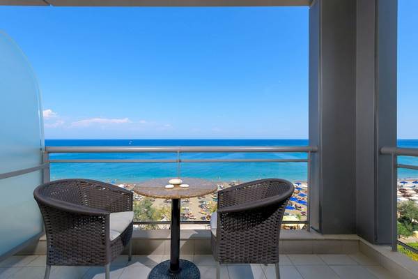 Balkonblick auf das Meer am Mediterranean Hotel in Rhodos mit zwei Stühlen und einem Tisch.