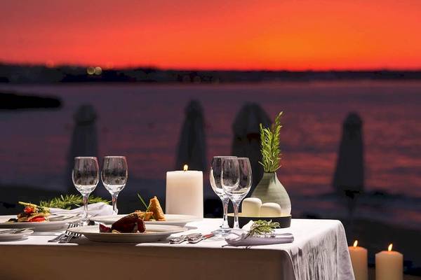 Abendessen mit Meerblick im Kernos Beach Hotel & Bungalows mit gedecktem Tisch und Kerzen.