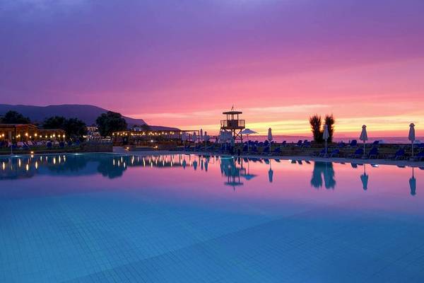 Abendstimmung am Swimmingpool des Kernos Beach Hotel & Bungalows mit buntem Himmel und Sonnenuntergang.