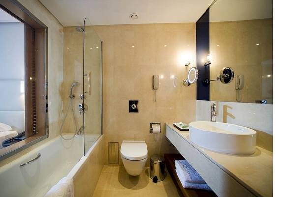 Badezimmer im Kernos Beach Hotel & Bungalows mit Badewanne, Dusche, Toilette und Waschbecken.