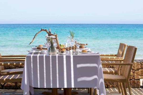 Tisch am Strand vor dem Kernos Beach Hotel mit Blick auf das Meer.