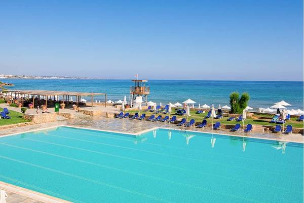 Außenbereich des Kernos Beach Hotel mit Swimmingpool und Sonnenliegen am Strand