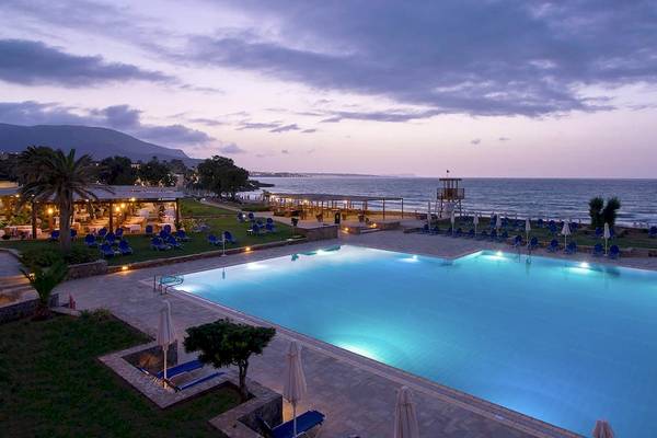 Abendliche Ansicht des beleuchteten Swimmingpools und der Liegewiese des Kernos Beach Hotel.