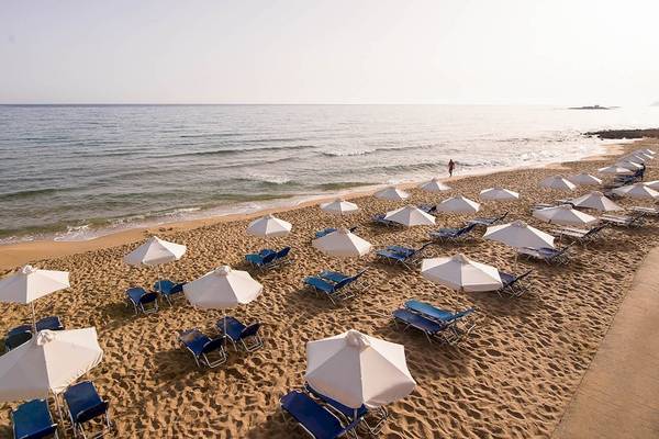 Luftaufnahme des Kernos Beach Hotels Strand mit Sonnenliegen und Sonnenschirmen