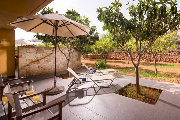 Terrasse mit Sonnenliegen und Sonnenschirm im Kernos Beach Hotel & Bungalows