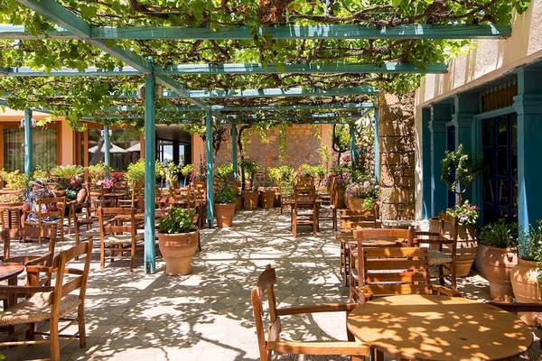 Terrasse des Kernos Beach Hotel mit Sitzplätzen und Blumen in Töpfen