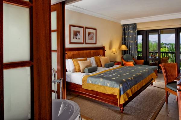 Schlafzimmer im Maritim Resort & Spa Mauritius mit großem Bett und Balkonzugang.