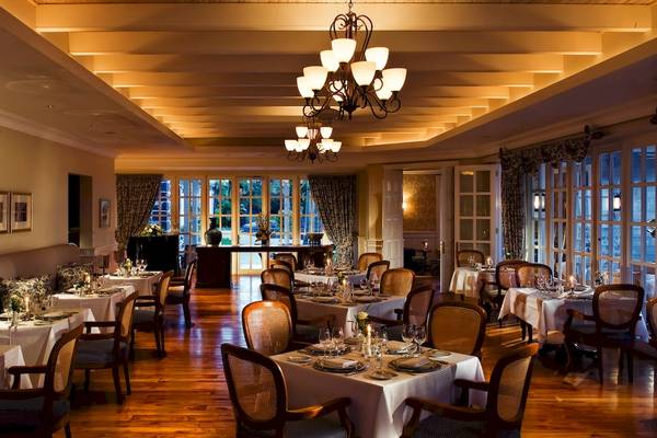 Innenbereich des Maritim Resort & Spa Mauritius mit gedeckten Tischen, Stühlen und Kronleuchtern.