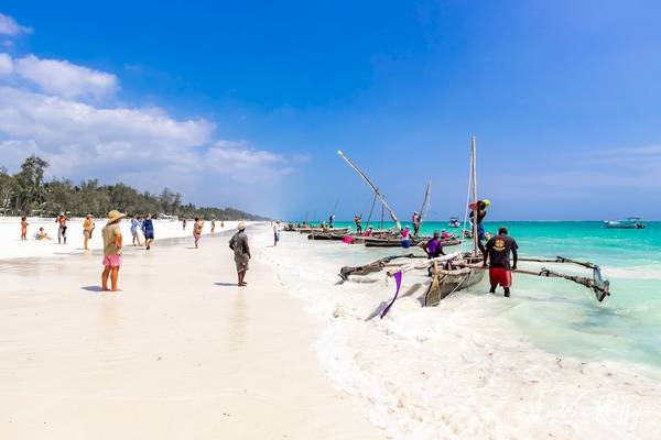 Eine Sandstrand mit einigen Leuten und Booten im Wasser