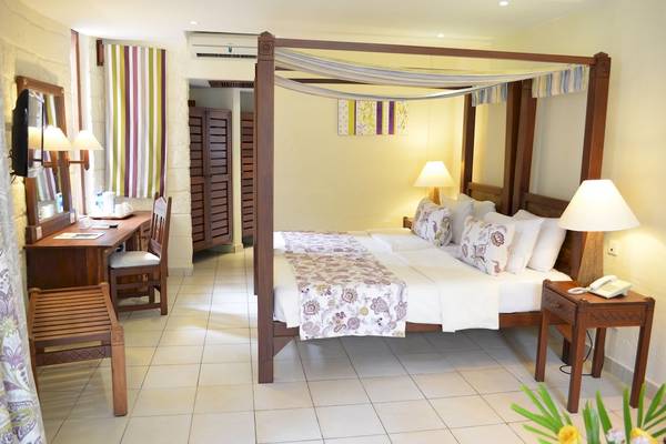 Schlafzimmer im Baobab Beach Resort & Spa mit einem Baldachinbett, Schreibtisch und Stuhl.