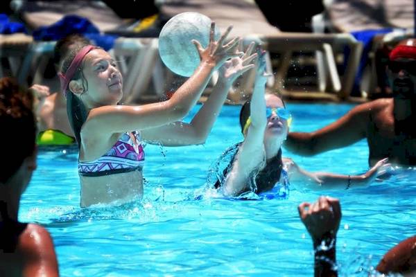 Mehrere Personen spielen Wasserball im Pool im Baobab Beach Resort & Spa.