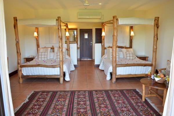 Doppelzimmer im Baobab Beach Resort & Spa mit zwei Holzbetten und luxuriöser Einrichtung.