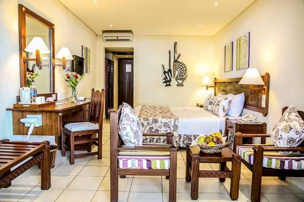 Zimmer im Baobab Beach Resort & Spa mit Bett, Schreibtisch, Stühlen und Obstteller