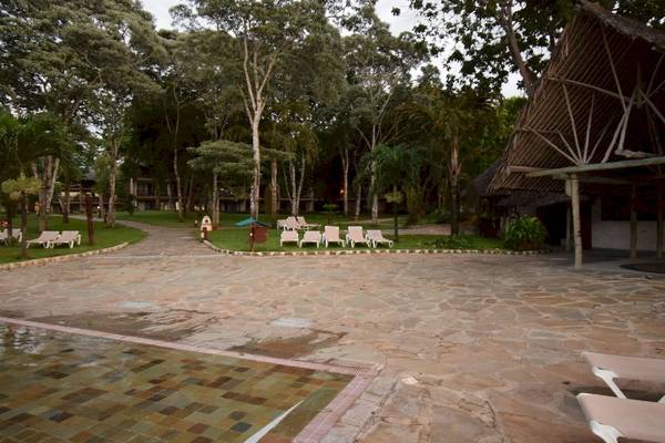 Außenbereich des Baobab Beach Resort & Spa mit Liegen und tropischen Bäumen