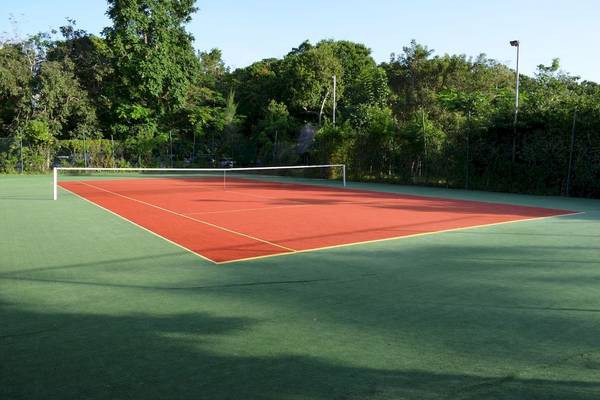 Tennisplatz im Freien im Baobab Beach Resort & Spa mit roten und grünen Spielflächen.