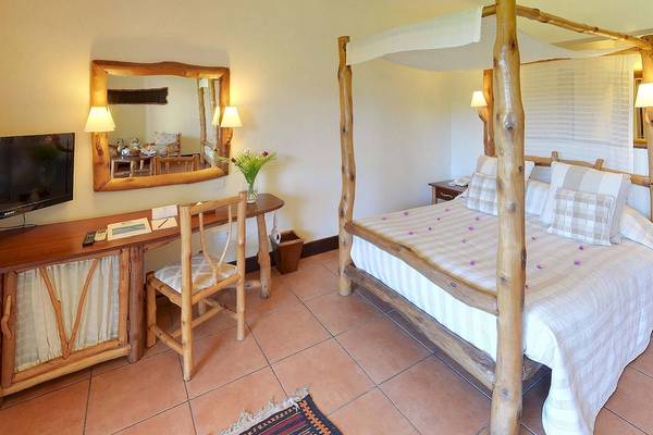 Hotelzimmer im Baobab Beach Resort & Spa mit Himmelbett, Schreibtisch und Fernseher.