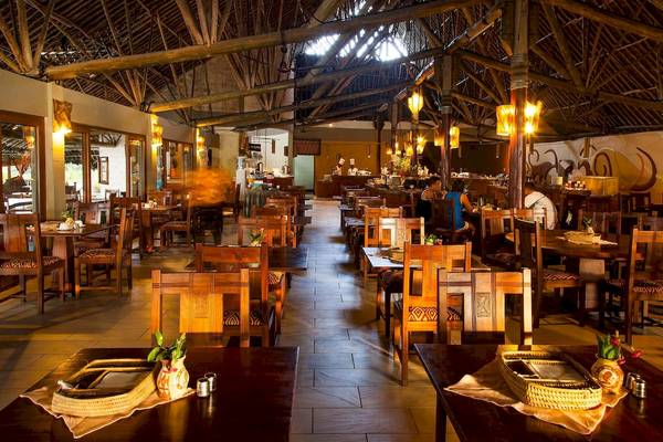 Innenbereich des Baobab Beach Resort & Spa mit gedämpften Lichtern und holzverkleideten Wänden.