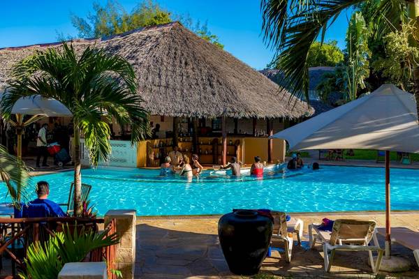 Poolbereich im Baobab Beach Resort & Spa mit Personen, die im Wasser und unter Sonnenschirmen entspannen.