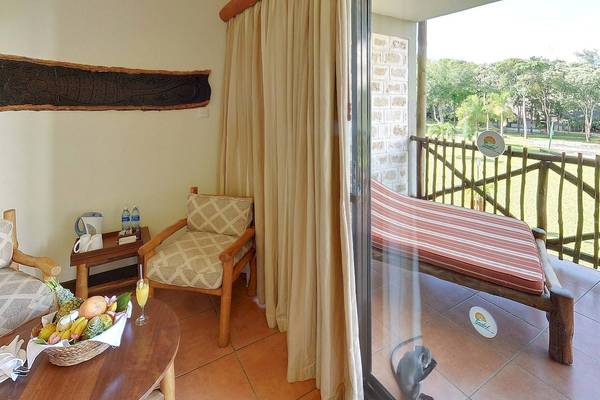 Ein Zimmer im Baobab Beach Resort & Spa mit Blick auf den Park, mit einem Tisch, zwei Stühlen, einer Couch und einem Fenster.