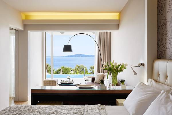 Schlafzimmer mit Meerblick im MarBella Corfu Hotel, mit großem Bett, Schreibtisch und Ausblick auf den Pool.