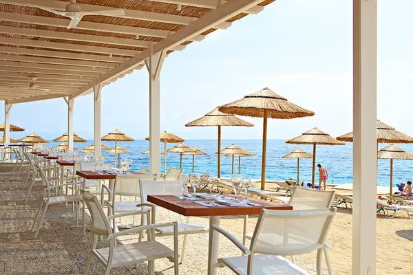 MarBella Corfu Hotel - Restaurant am Strand mit Sonnenschirmen und Tischen.
