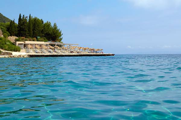 MarBella Corfu Hotel mit Liegestühlen und Sonnenschirmen am Strand