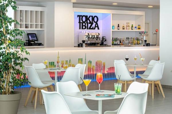 Innenansicht der Cocktail-Bar des Vibra Algarb Hotels mit weißen Stühlen, Tischen und einer grünen Pflanze.