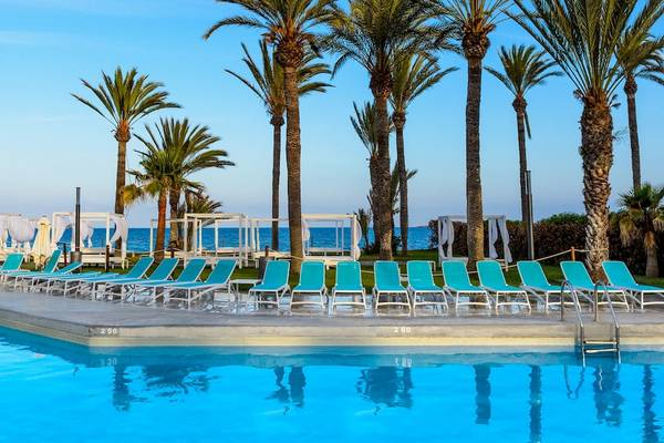 Schwimmbad am Strand des Vibra Algarb Hotels mit blauen Sonnenliegen und Palmen