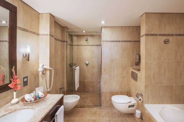 Badezimmer im Khalidiya Palace Rayhaan by Rotana Hotel mit Dusche, Toilette und Badewanne.