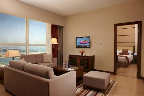 Innenansicht einer Suite im Khalidiya Palace Rayhaan by Rotana Hotel mit Blick auf das Meer.