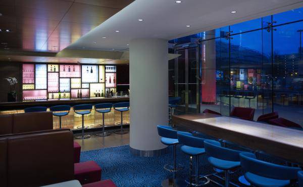 Innenansicht der Bar im Park Plaza County Hall London Hotel mit blauen Stühlen und einem langen Tisch.