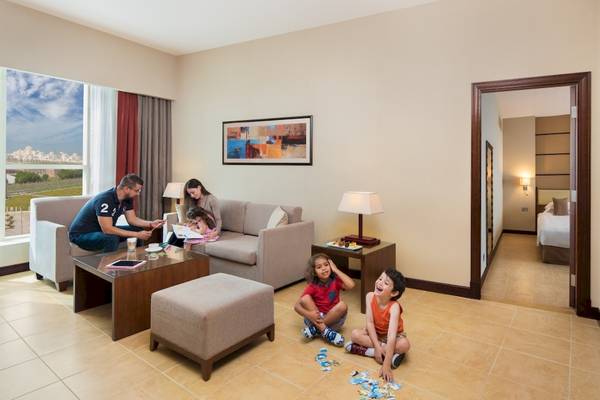 Familie im Wohnzimmer des Khalidiya Palace Rayhaan by Rotana, sie spielen Puzzle